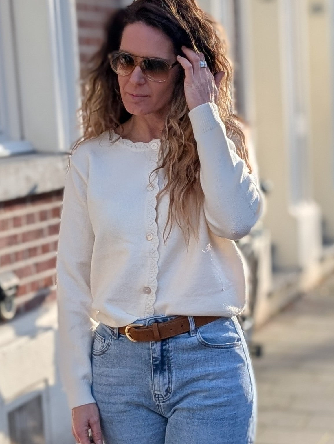 Wit gebreid vestje, met sierlijke rand en kantdetails